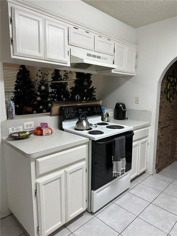 2104 Fairmont Ave, Mcallen, TX 78504 - kitchen with electric range, under cabinet range hood, arched walkways, light countertops, and a textured ceiling