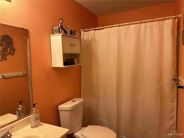 bathroom featuring vanity, a textured ceiling, and toilet