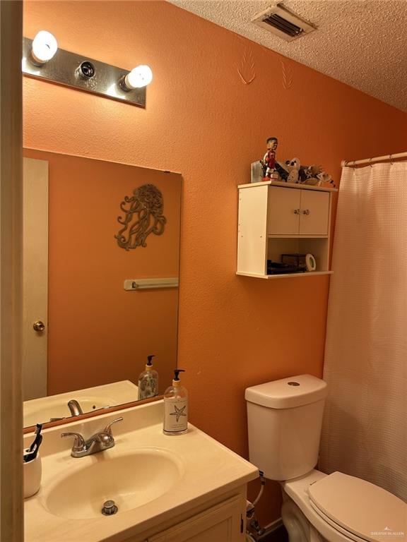 bathroom featuring vanity, toilet, and a textured ceiling