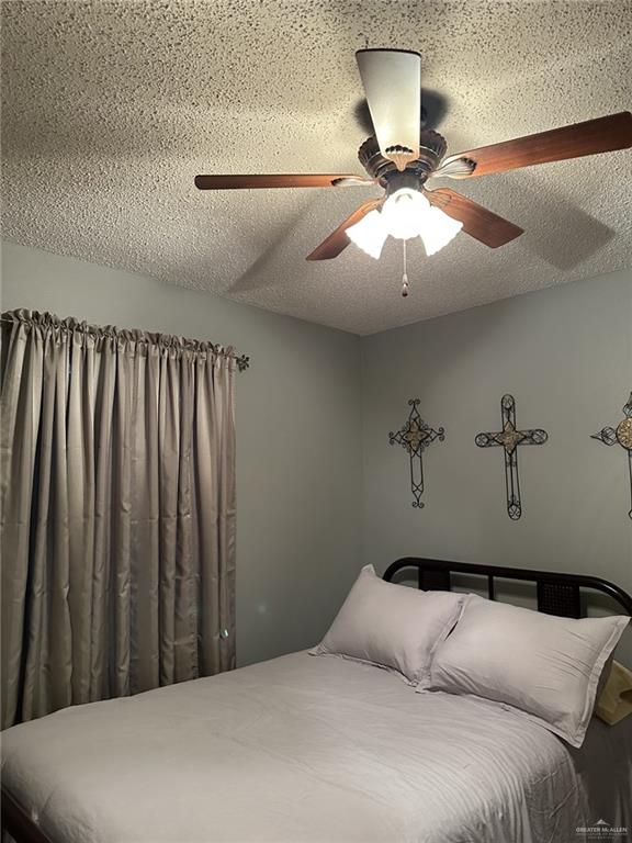 bedroom featuring ceiling fan and a textured ceiling