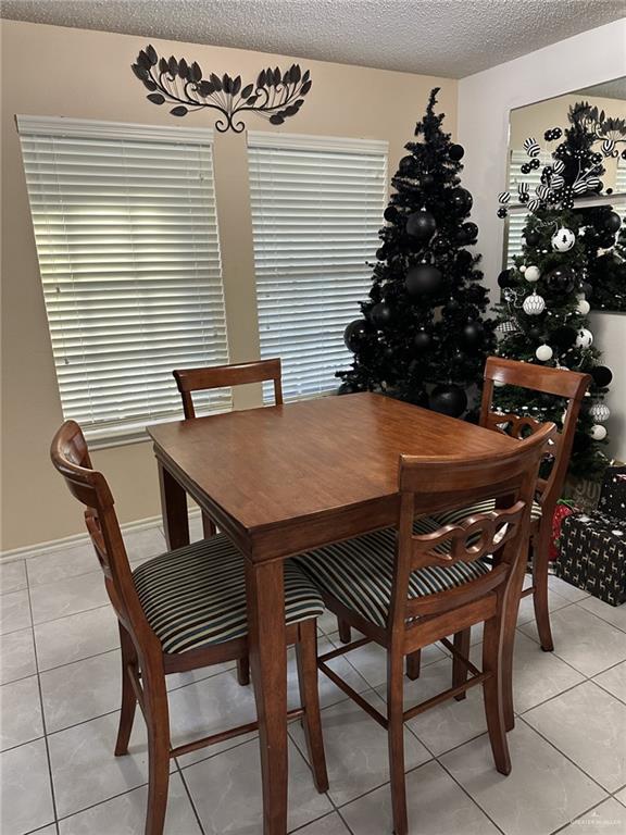 dining space with light tile patterned flooring and a textured ceiling