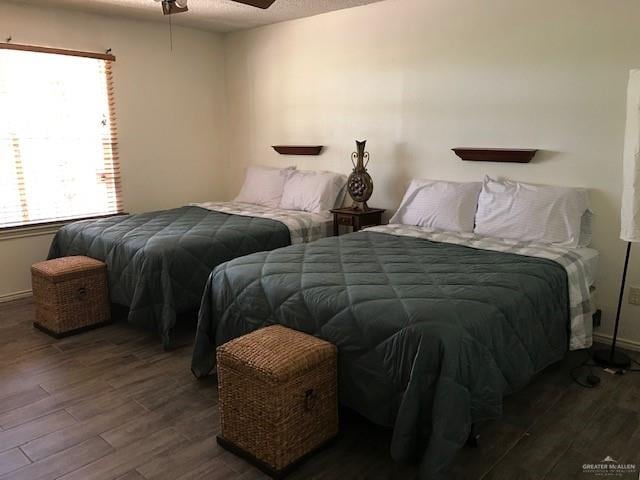 bedroom with dark hardwood / wood-style floors and ceiling fan