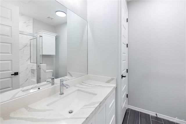 bathroom featuring hardwood / wood-style flooring, a shower with door, vanity, and toilet