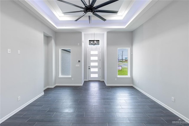 foyer with ceiling fan, dark hardwood / wood-style floors, and a tray ceiling