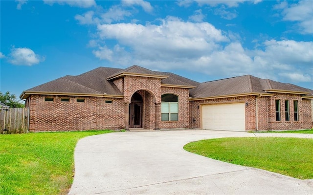 503 W 12th St, Weslaco, TX 78596 - view of front of home featuring curved driveway, brick siding, a garage, and a shingled roof