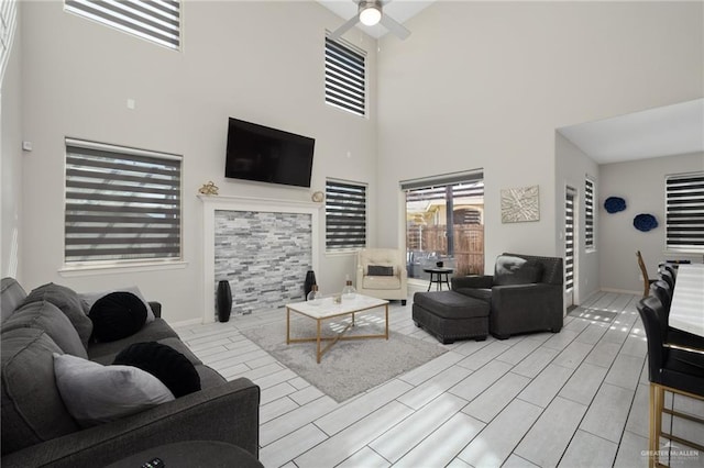 living room featuring ceiling fan and a high ceiling