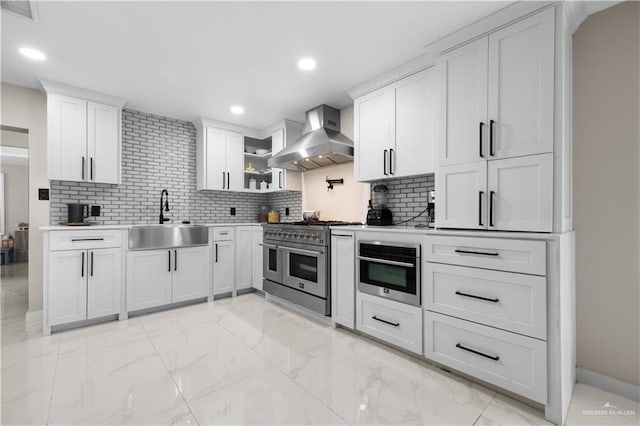1201 S Danner Rd, Pharr, TX 78577 - kitchen featuring wall chimney range hood, range with two ovens, decorative backsplash, light marble finish flooring, and white cabinets