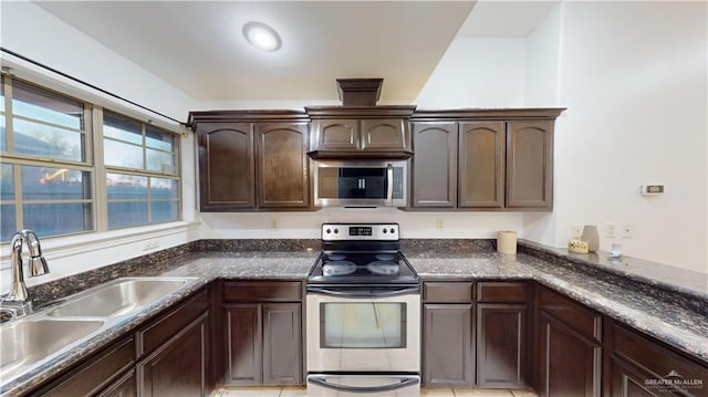 kitchen with appliances with stainless steel finishes, dark brown cabinetry, light tile patterned floors, and sink