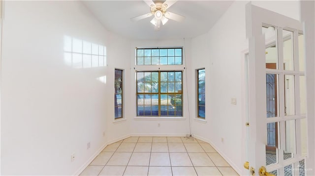 tiled foyer with ceiling fan and a towering ceiling