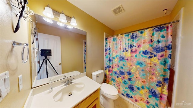 bathroom with walk in shower, vanity, and toilet