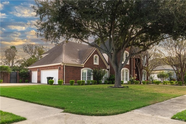 view of front of home featuring a garage and a yard