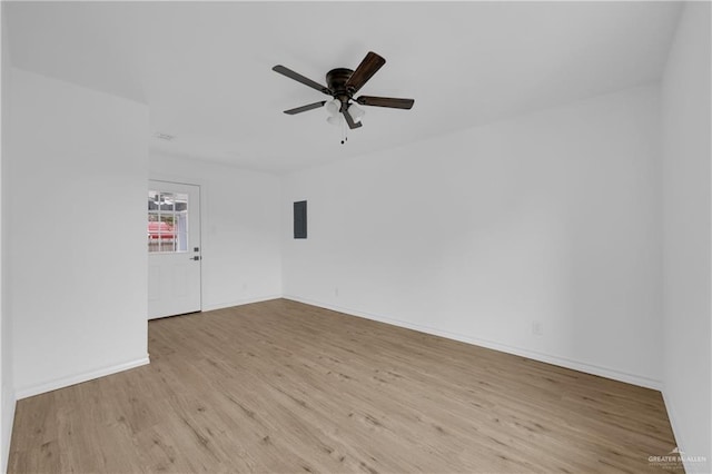 spare room featuring ceiling fan, electric panel, and light hardwood / wood-style floors