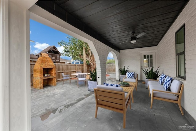 view of patio with an outdoor living space with a fireplace and ceiling fan