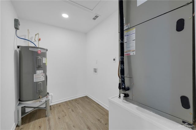 utility room featuring water heater and heating unit