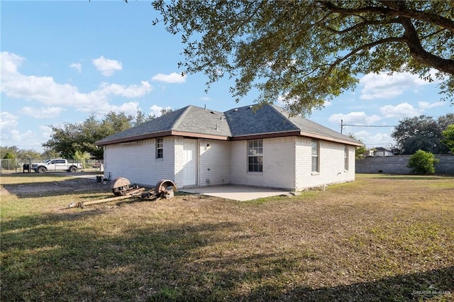 back of house with a lawn and a patio