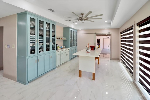 5804 La Quinta Ln, Weslaco, TX 78599 - kitchen featuring a barn door, light marble finish floors, blue cabinets, light countertops, and recessed lighting