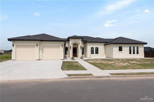 5407 Common Ln, Weslaco, TX 78596 - french country style house featuring an attached garage, concrete driveway, stucco siding, and stone siding