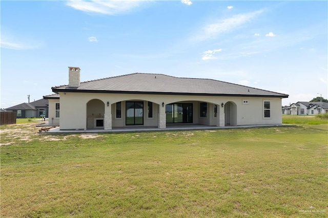 5407 Common Ln, Weslaco, TX 78596 - back of property featuring a chimney, a lawn, a patio, and stucco siding