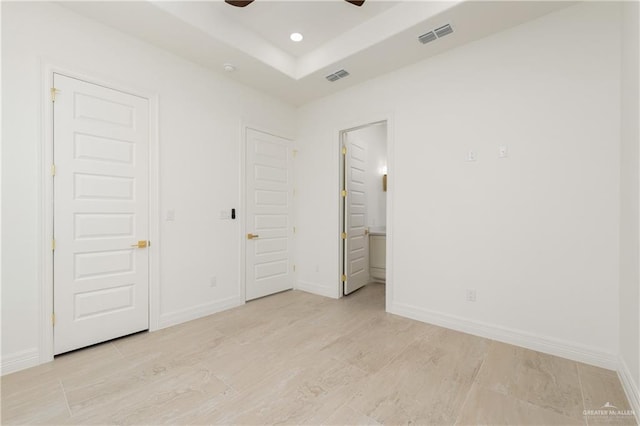 5407 Common Ln, Weslaco, TX 78596 - unfurnished bedroom featuring a raised ceiling, baseboards, recessed lighting, ensuite bath, and ceiling fan