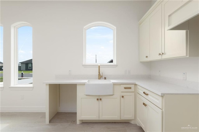 5407 Common Ln, Weslaco, TX 78596 - kitchen with a sink, light countertops, baseboards, and white cabinets