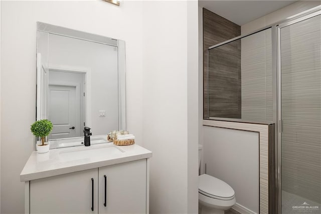 bathroom featuring walk in shower, vanity, and toilet