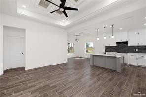 kitchen with a ceiling fan, decorative backsplash, open floor plan, white cabinets, and dark wood-type flooring