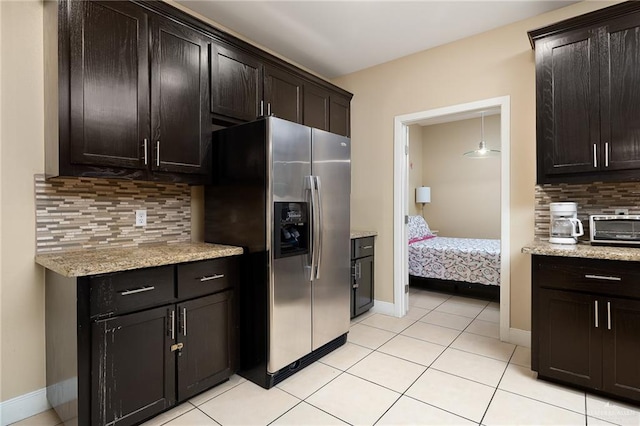 kitchen featuring dark brown cabinets, stainless steel fridge, and backsplash