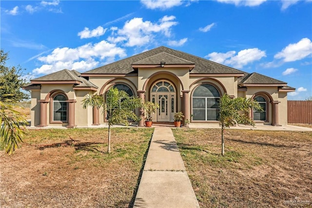 mediterranean / spanish home with a front lawn and french doors