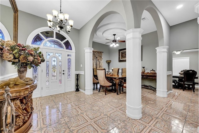 tiled foyer entrance featuring ceiling fan with notable chandelier, decorative columns, and a high ceiling