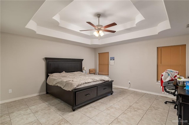 bedroom with a raised ceiling, visible vents, baseboards, and ceiling fan