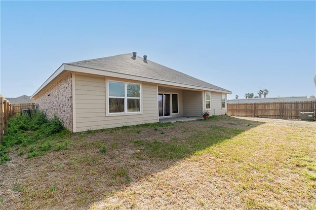 back of house with a lawn, a fenced backyard, and a patio