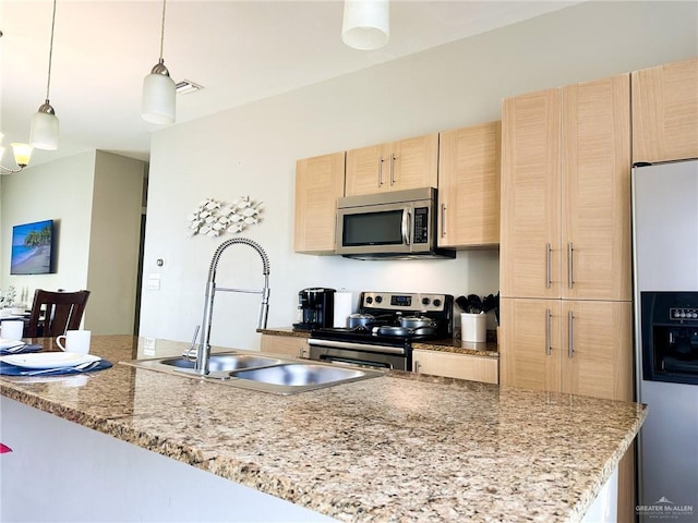 kitchen with sink, light stone counters, decorative light fixtures, light brown cabinets, and stainless steel appliances