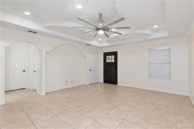 unfurnished room with light tile patterned floors, a tray ceiling, ceiling fan, and crown molding