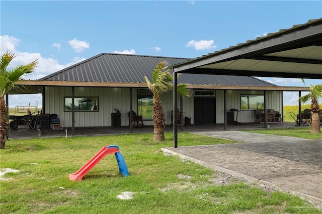 2115 Mile 3 N, Mercedes, TX 78570 - back of house featuring board and batten siding, a lawn, and metal roof