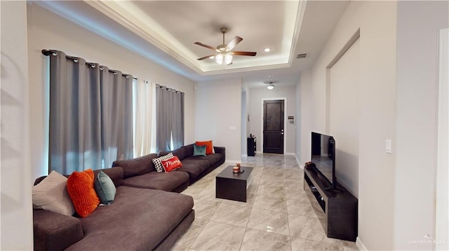 living room featuring ceiling fan and a tray ceiling