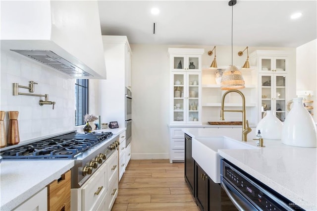 kitchen with custom exhaust hood, appliances with stainless steel finishes, tasteful backsplash, and glass insert cabinets