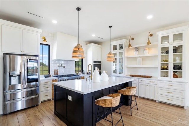 kitchen featuring open shelves, white cabinets, light wood finished floors, and stainless steel appliances