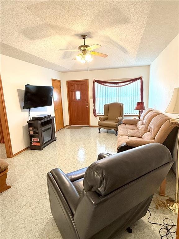 living room with a textured ceiling and ceiling fan