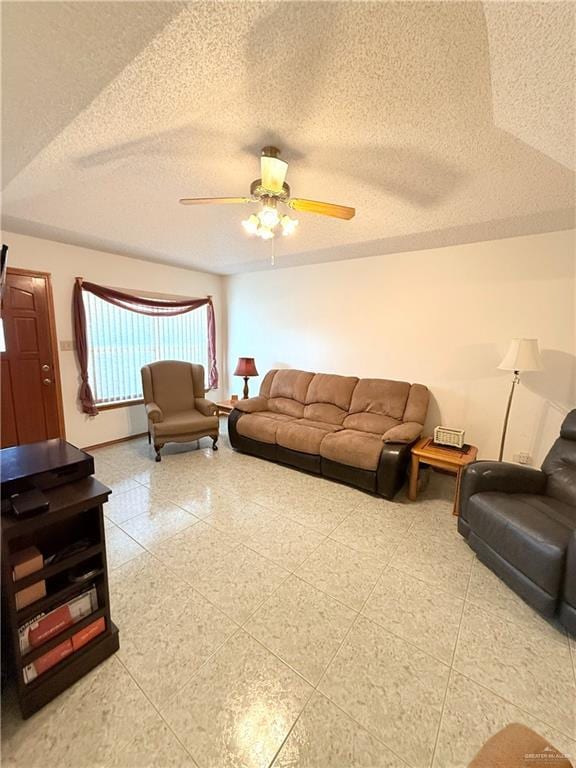 living room featuring ceiling fan and a textured ceiling