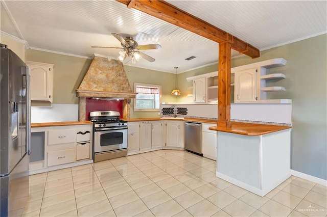 kitchen featuring premium range hood, ornamental molding, pendant lighting, stainless steel appliances, and white cabinets