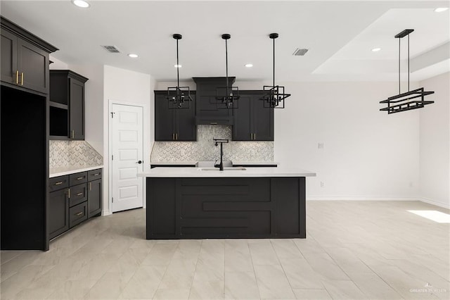 kitchen featuring visible vents, black fridge, light countertops, and a sink