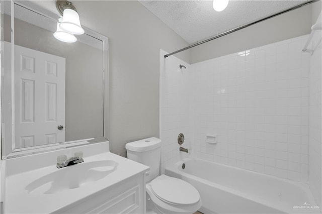 full bathroom with vanity, tiled shower / bath combo, toilet, and a textured ceiling