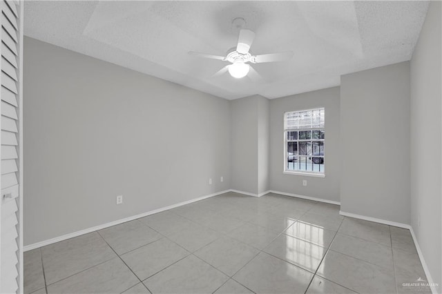 tiled spare room with a textured ceiling and ceiling fan