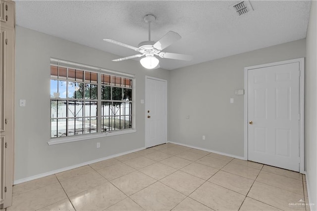 tiled spare room featuring ceiling fan and a textured ceiling