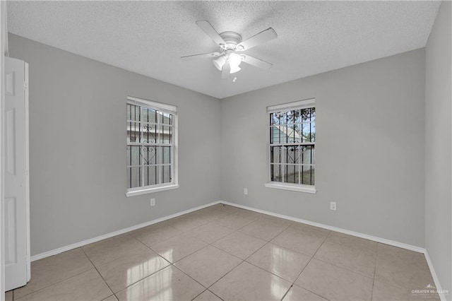 spare room with light tile patterned flooring, a textured ceiling, and ceiling fan