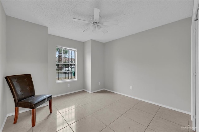 unfurnished room with light tile patterned floors, a textured ceiling, and ceiling fan