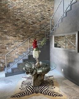 staircase with a towering ceiling and brick wall