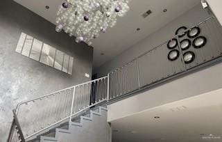 stairs featuring an inviting chandelier