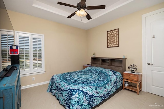 bedroom featuring a raised ceiling and ceiling fan