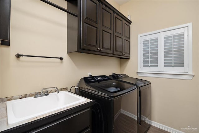 washroom with hardwood / wood-style floors, cabinets, sink, and washer and dryer